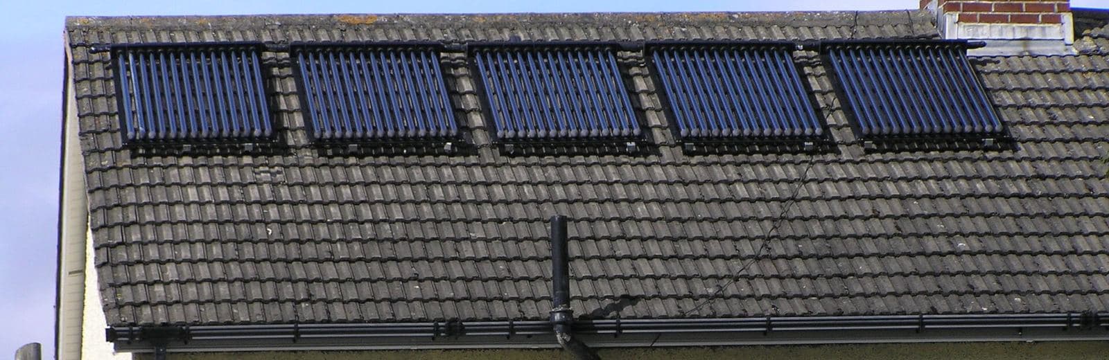 Capteurs solaires à tubes sous vide alignés sur une toiture en tuiles, à Dublin