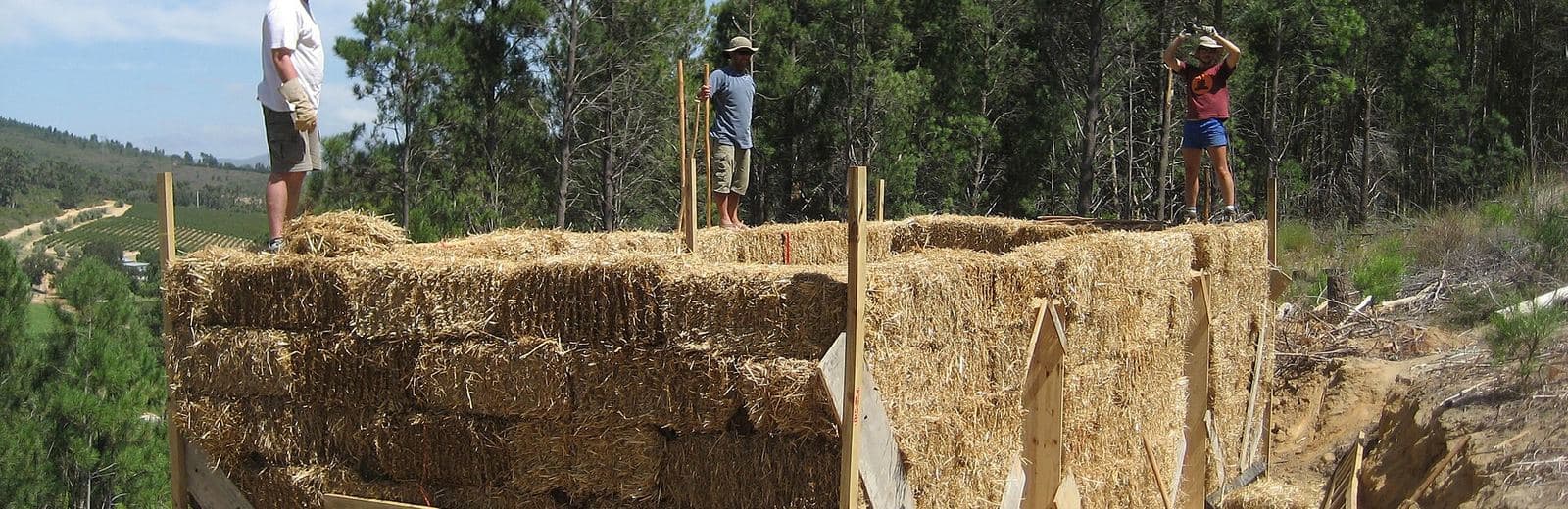 Chantier d'un mur en bottes de paille, avec ossature bois