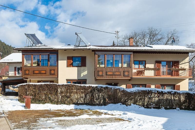 Maison avec panneaux solaires en toiture, sous la neige, à Pörtschach (Autriche)