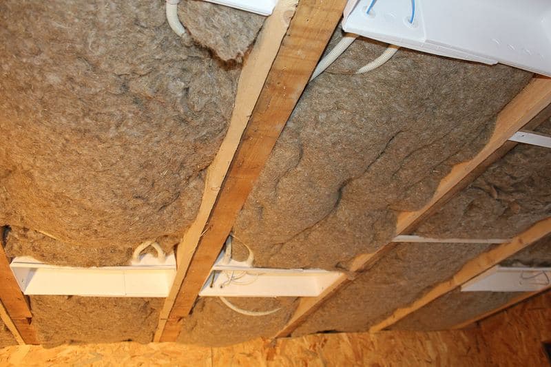 Isolant en fibres de lin posé entre des lambourdes de plafond